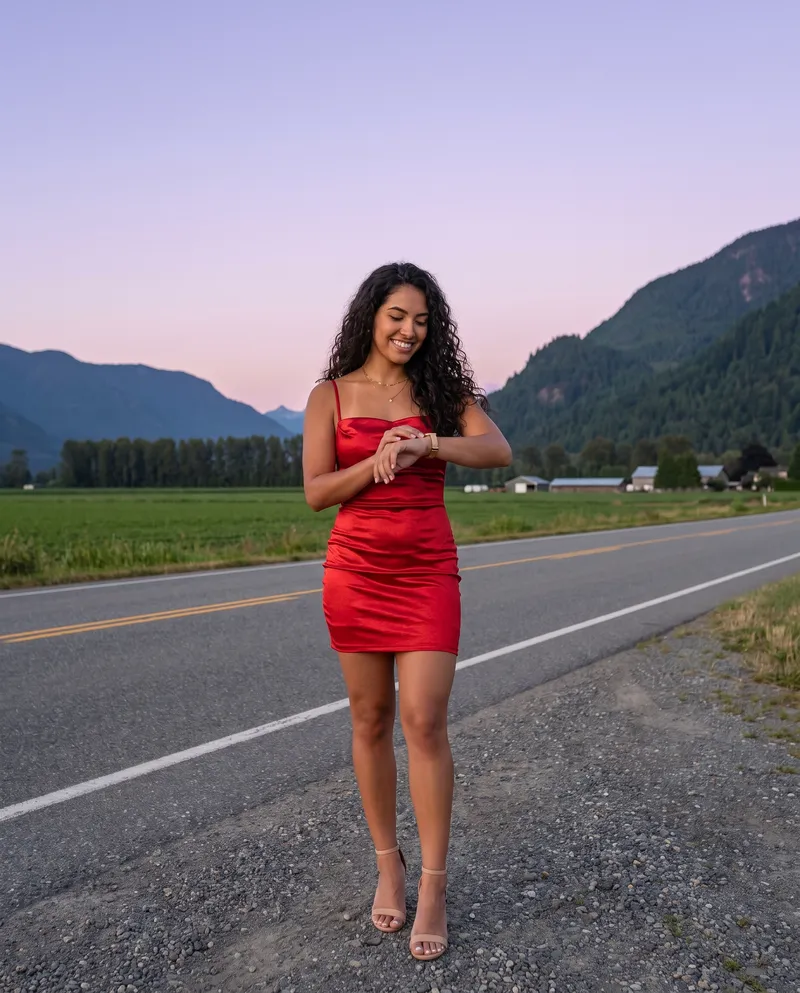 Woman checking her watch on a valley road at dusk